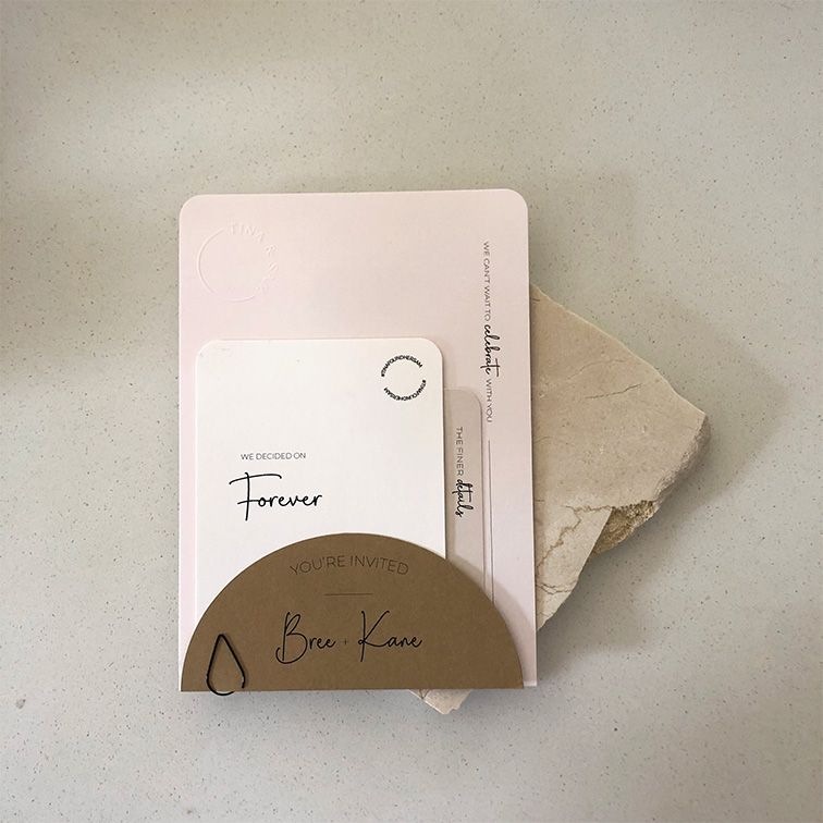 Modern wedding invitation suite for Tina and Sam styled with soft neutrals and natural stone