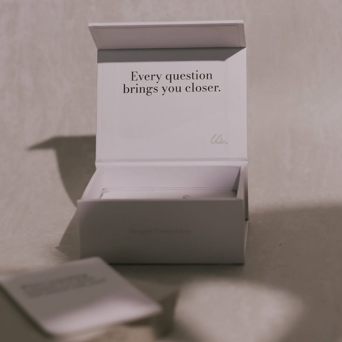 Exploring Us box interior showing tagline "Every question brings you closer" with premium unboxing experience design and subtle branding