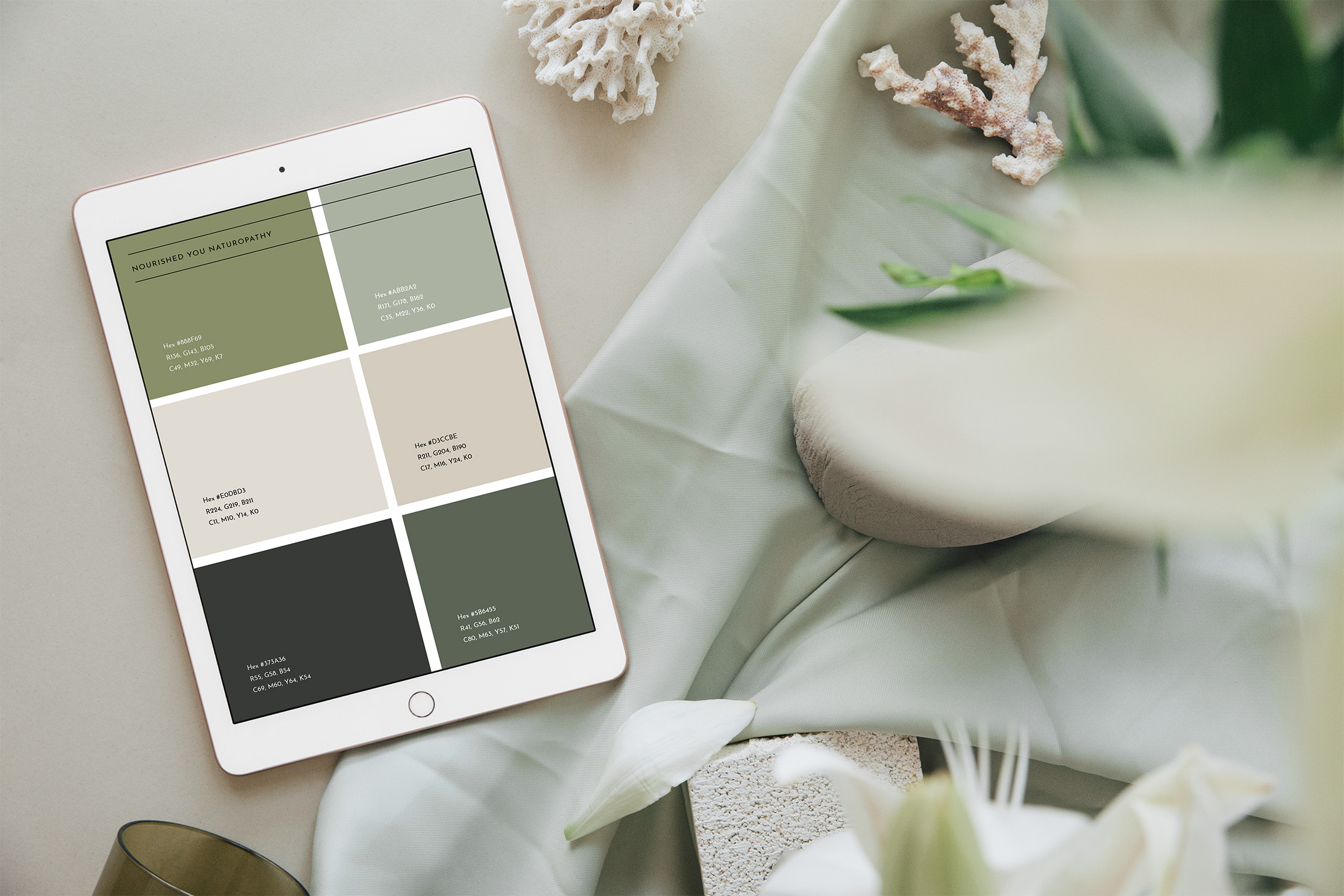 Nourished You colour palette displayed on iPad showing sage green, cream, charcoal, and accent colours with hex codes for brand consistency
