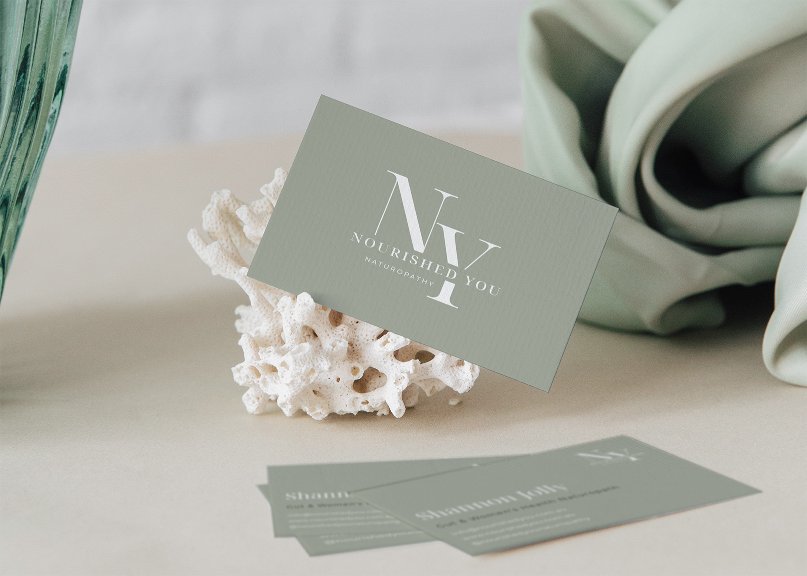 Nourished You premium business card in sage green on cream with minimalist logo and naturopathy credentials displayed