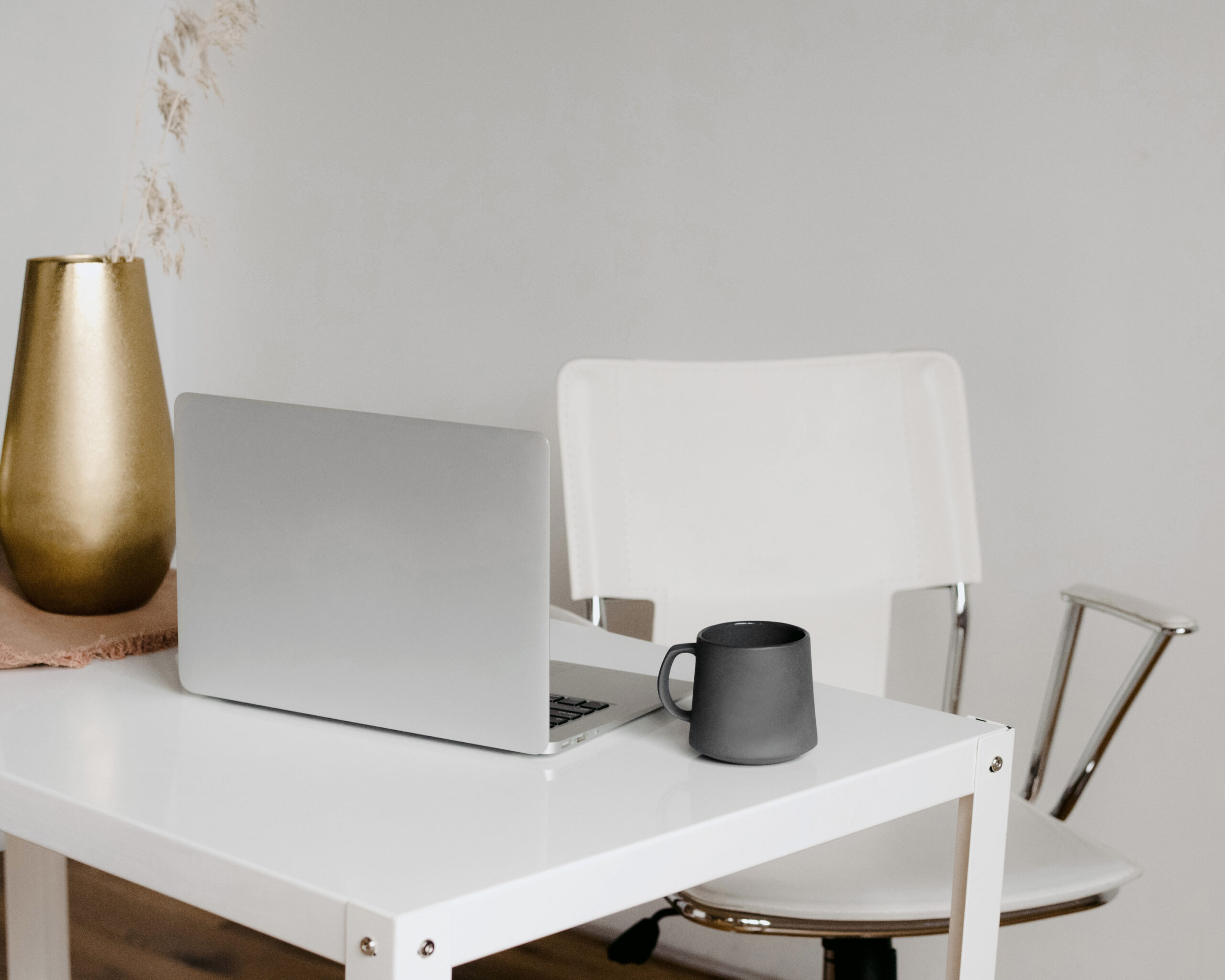 Minimalist workspace of brand and website designer Geelong showing laptop, white desk organizer, and design studio setup with neutral aesthetic